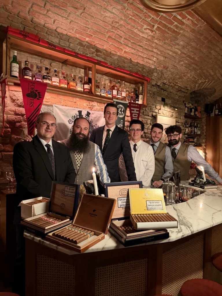 Benjamin Fabio Cavagna, Nicola Di Nunzio, Luca Borla, Franz-Arthur MacElhone e Patrick Dooley dietro il bancone del 1930 Milano per l'evento con l'Harry's Bar di Parigi, con scatole di sigari Habanos in evidenza.