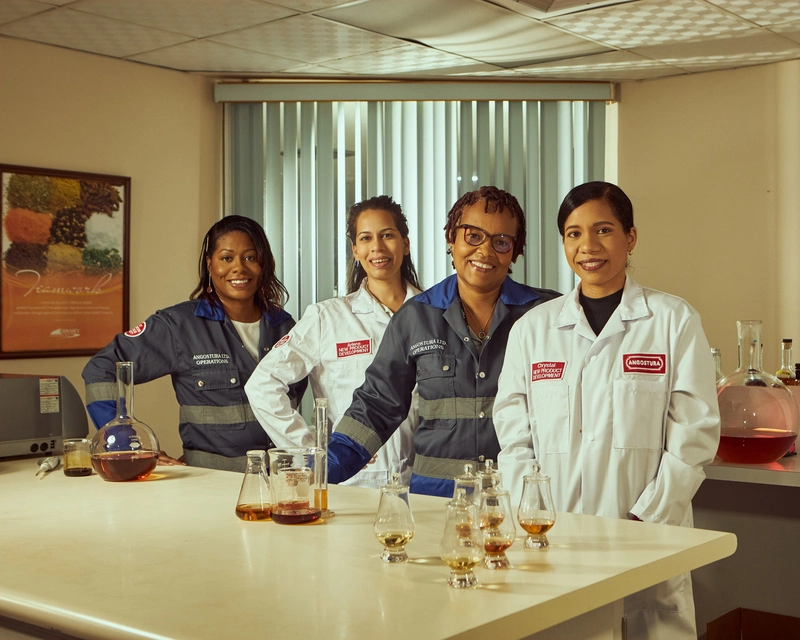 Il team di produzione e blending di The House of Angostura in laboratorio con camici bianchi, alambicchi e bicchieri da degustazione rum
