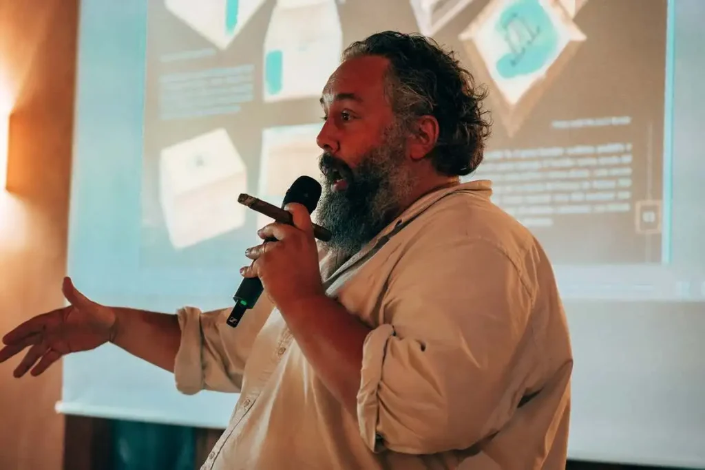 Angelo Canessa parla al microfono tenendo in mano un sigaro durante il primo giorno di seminari tecnici al XX Amigos de Partagás a Matelica.