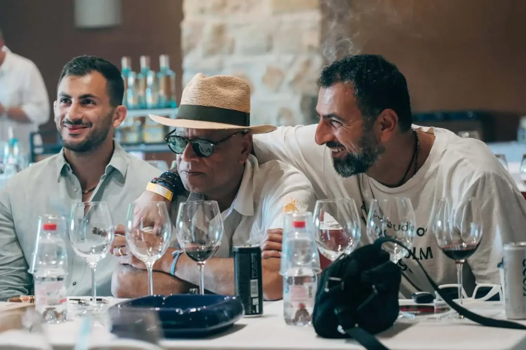Un gruppo di appassionati ed esperti di sigari cubani sorride e dialoga ai tavoli del festival durante una sessione tecnica pomeridiana.