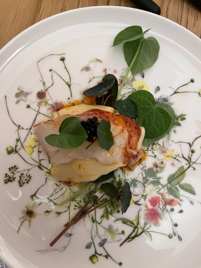 Il tipico antipasto giapponese Chawanmushi servito con tartare di astice, caviale e foglie verdi su un piatto finemente decorato da Akoya Torino.