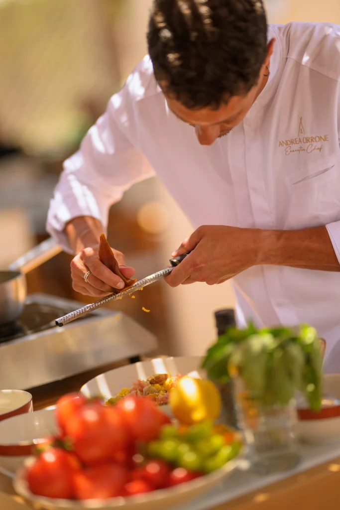 L'Executive Chef Andrea Cirrone grattugia la bottarga sulla fregula sarda per il menu 2026 di Nikki Beach Costa Smeralda
