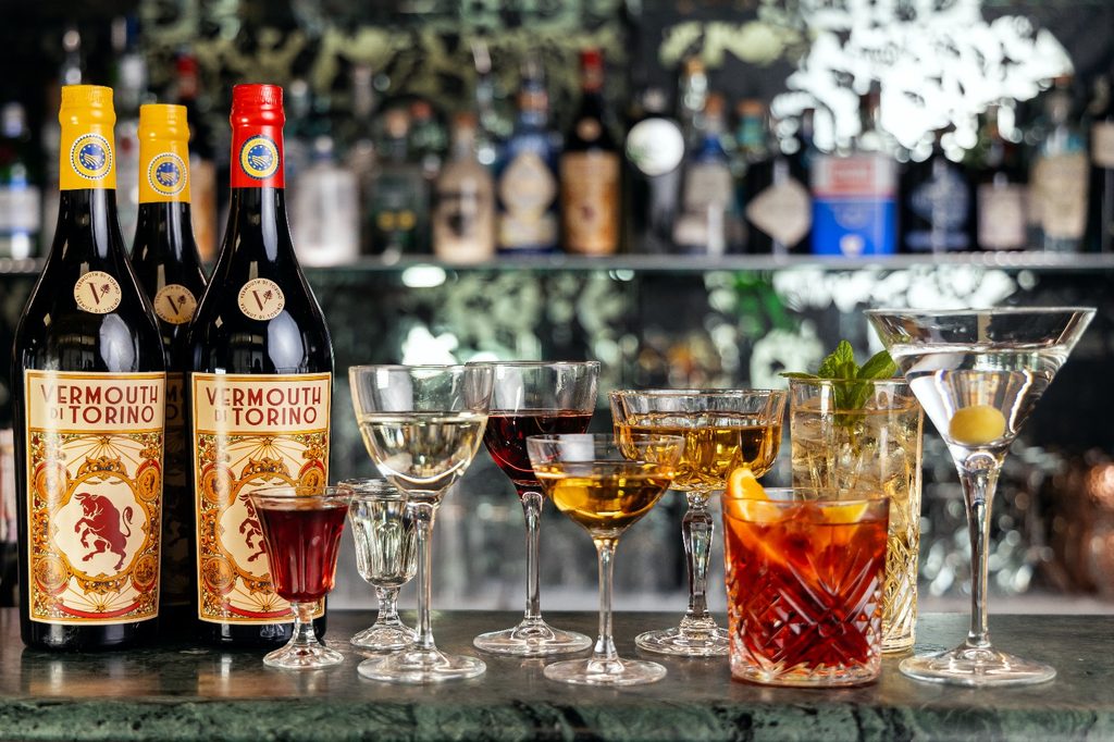 Cocktail e bottiglia di Vermouth di Torino IGP con etichetta ufficiale del Consorzio del Vermouth di Torino.