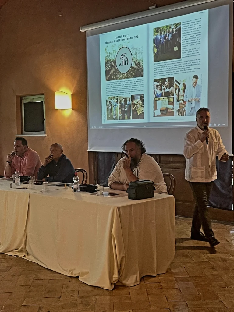 Il tavolo con i relatori che presentano le slide tecniche proiettate sullo schermo durante il XX Amigos de Partagás.