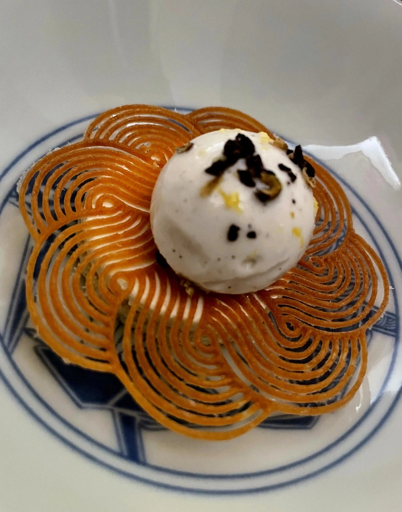 Il dessert d'autore firmato da Matilde Pangrazi da Akoya Torino, caratterizzato da una cialda geometrica, gelato e rifinitura al cacao.