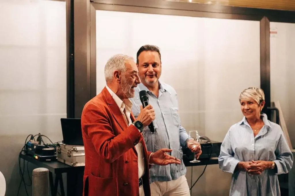 Francesco Minetti al microfono insieme ad Alexandre Avellar e Raquel Mayedo durante l'inaugurazione