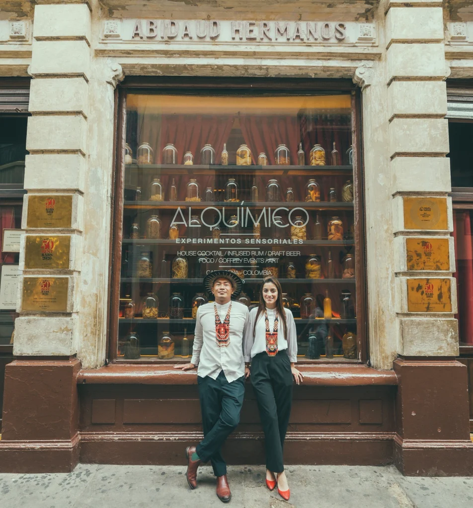 Jean Trinh e Paola Oviedo, fondatori di Alquímico a Cartagena, posano davanti alla facciata esterna del bar.