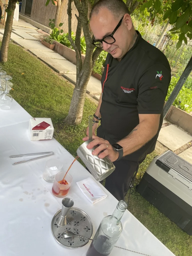 Il bartender Jimmy Bertazzoli della sosta Aguardiente mentre versa il cocktail MI.TO numero 5 durante l'evento.