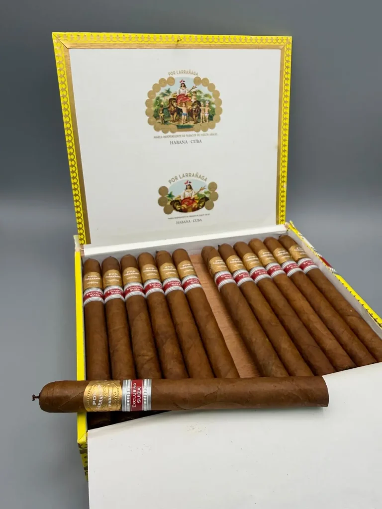 Un sigaro Por Larrañaga Intemporales in primo piano appoggiato sulla sua scatola originale Edición Regional Suiza.