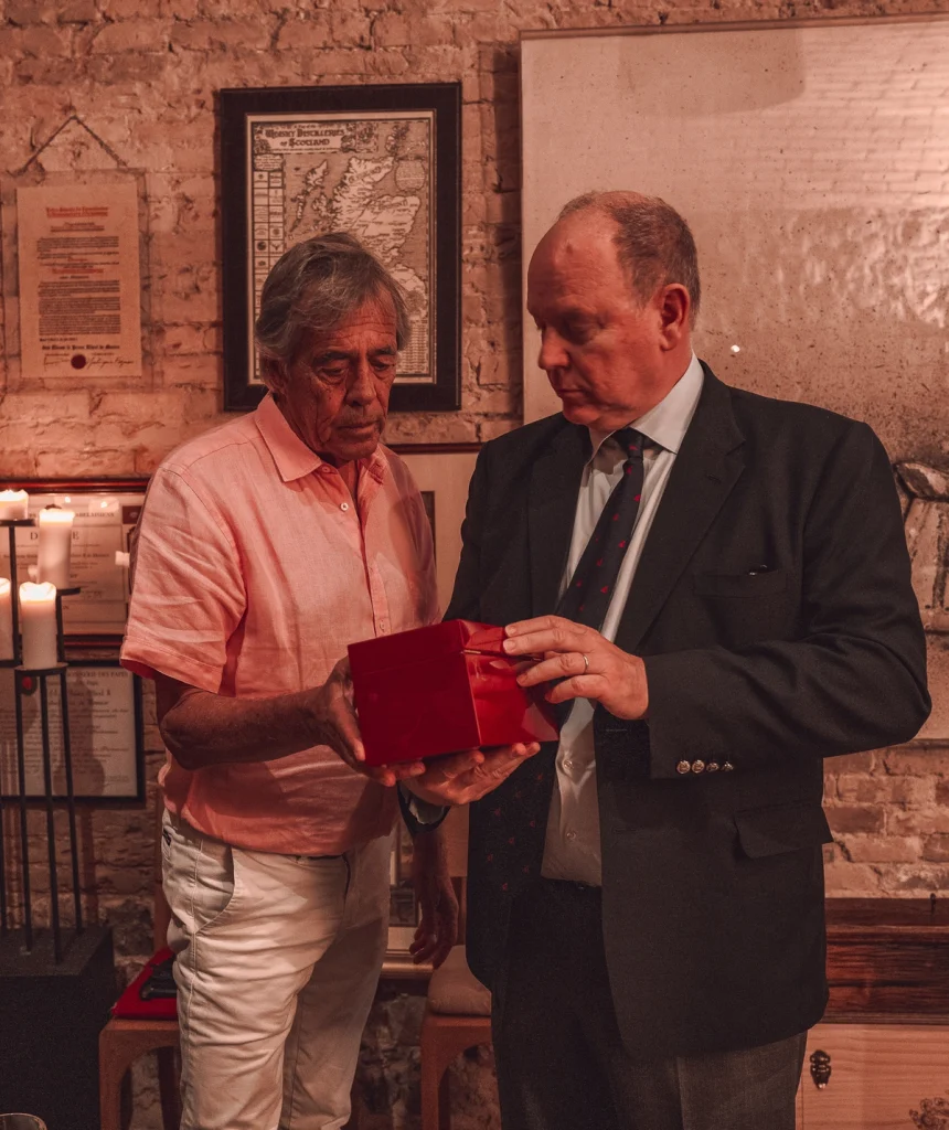 Il Principe Alberto II di Monaco osserva una confezione regalo durante l'evento di presentazione del rum tradizionale A Mesccia.
