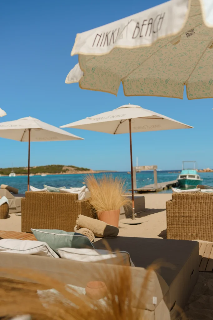 Area lounge in spiaggia con ombrelloni brandizzati Nikki Beach in Costa Smeralda