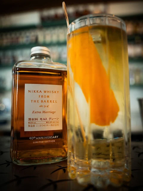 Cocktail servito accanto alla bottiglia di Nikka Whisky From The Barrel Extra Marriage 40th Anniversary