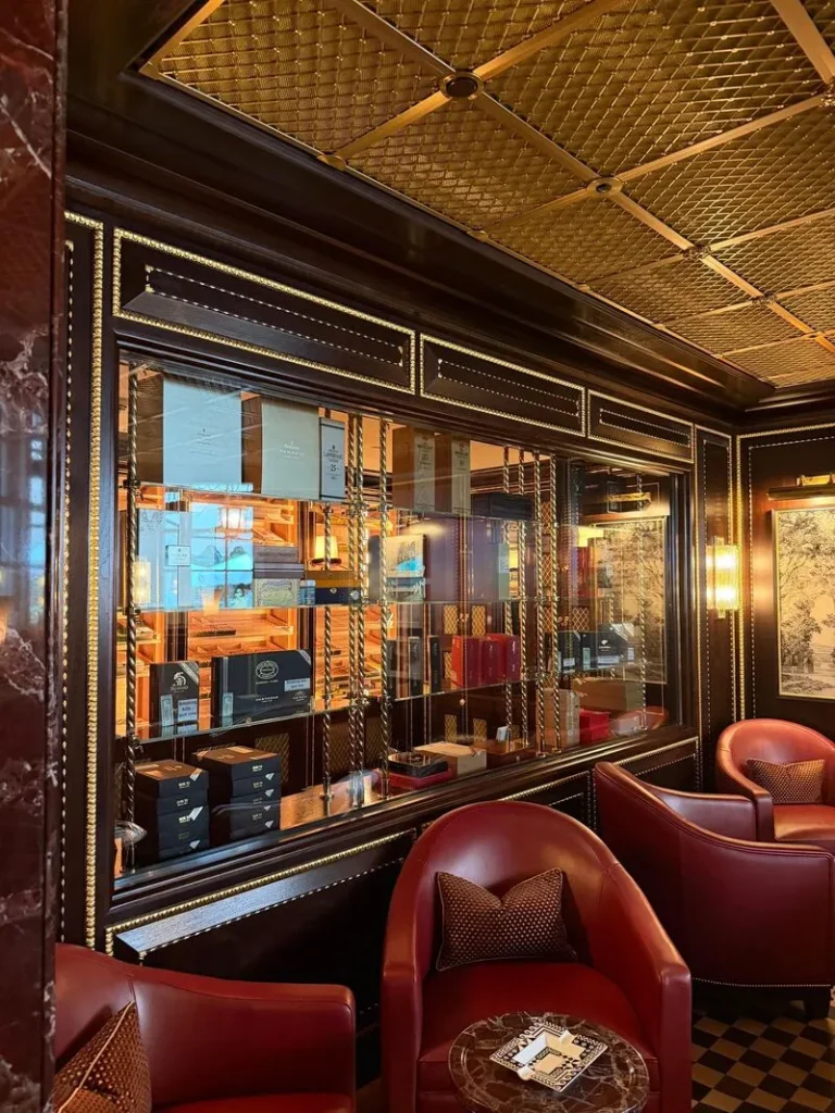 Grande vetrina climatizzata per la conservazione di sigari premium e distillati all'interno della sampling lounge del Ritz di Londra, con finiture dorate ed ebanisteria di lusso DeART.